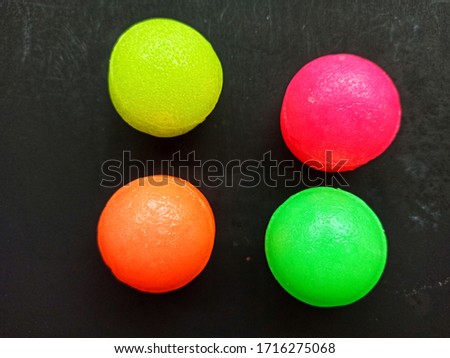 Colorful balls are isolated against a black background.
