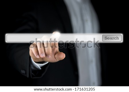 Businessman pushing a blank search bar on a virtual computer screen or interface with copyspace for your web address or keywords