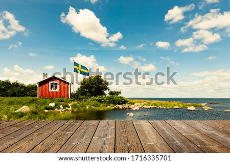 Red Swedish house with wooden terrace Royalty-Free Stock Photo #1716335701