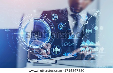 Unrecognizable African American businessman writing at blurry table with double exposure of futuristic online work interface. Toned image. Elements of this image furnished by NASA