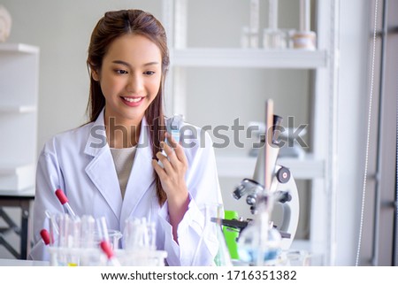 Attractive happiness scientist woman lab technician assistant showing alcohol hand gel for cleaning hands at laboratory. Medical, pharmaceutical and scientific research and development concept.