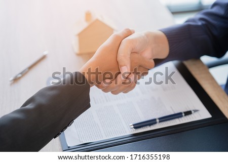 Real estate broker agent Shake hands after customer signing contract document for ownership realty purchase in the office, Business concept and  signing contract Royalty-Free Stock Photo #1716355198