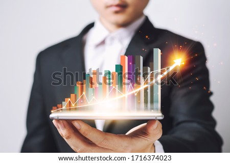 Businessmen Asia  holding Smartphone and showing a growing virtual hologram of statistics, graph and chart with arrow up on white background. Stock market. Business growth, planing concept.
