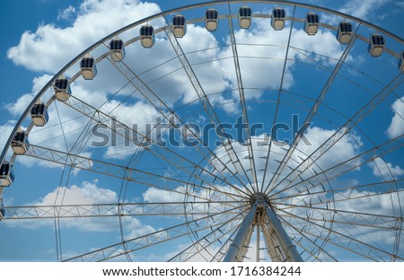 A modern white Ferris wheel against brilliant blue sky