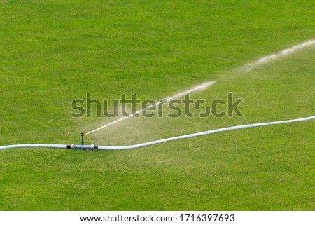 Sprinklers, connected via fire hoses, are seen watering a dry football field in Flums, Switzerland.