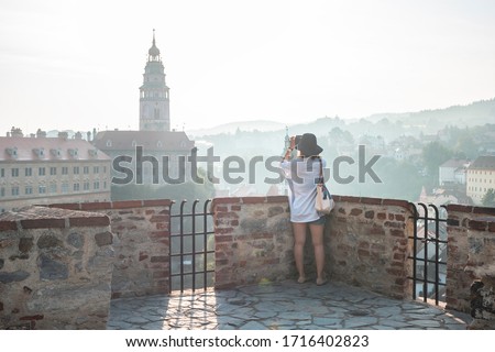 Photographer tourist taking pictures of European city Cesky Krumlov Czech Republic city on a sunny day with the castle in the background