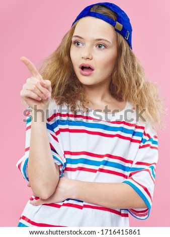 The girl in the striped T-shirt is pointing with his finger to the side