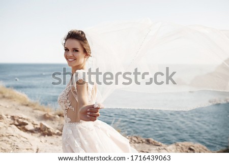 Portrait of a beautiful bride in wedding dress near the sea