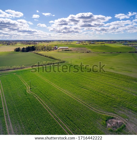 Drone photo over Swedish countryside with fields and barns