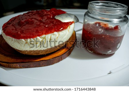 Strawberry cheesecake and a jar with strawberry jam