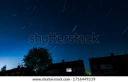 Long exposure shot of suburban night sky showing light trails of the stars for 30 minutes