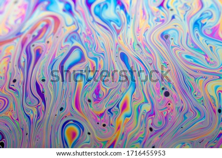 Abstract photo texture of a soap bubble. Background wallpaper iridescent colors on the surface of the iridescent spots.