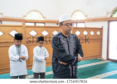 father and son praying together in the mosque. muslim people pray