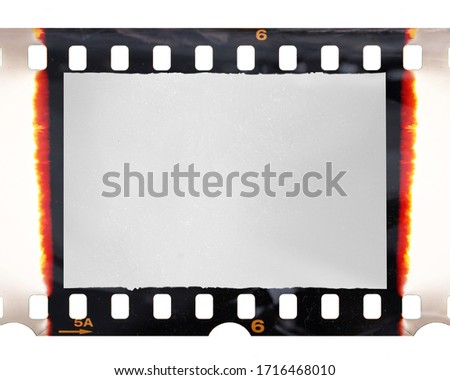 old fashioned 35mm filmstrip or dia slide frame with burned edges isolated on white background. Real analog film scan with signs of usage and foil effect.