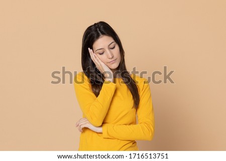 runette young woman wearing a yellow T-shirt on a yellow background