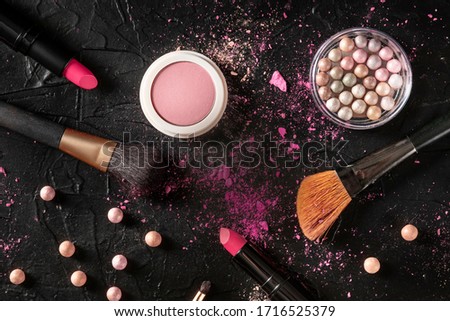 Professional make-up on a black background. Brushes, lipstick and other products, a flatlay with copyspace