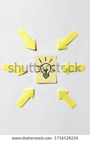 Pointing arrows indicate a sticker with a lamp, as a sign of a good idea. Concept of business, management, markets, creativity.