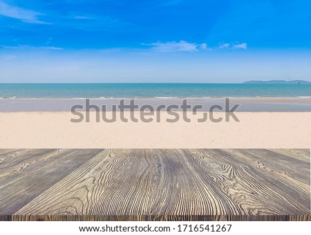 Wooden table top with blue sky beach and sand blurred background
