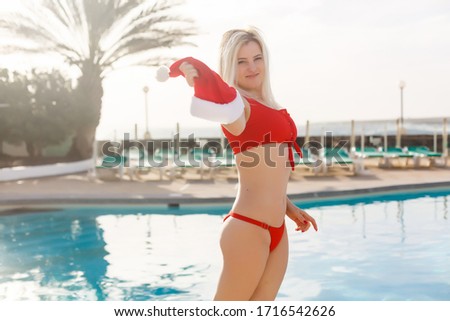 Pretty woman enjoying her christmas vacations near the pool.