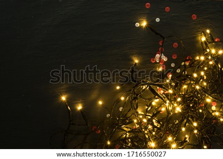 Christmas Warm Light on Natural Stone Background Top View with Copyspace. Beautiful Garland Lights Texture or New Year Pattern for Xmas Design