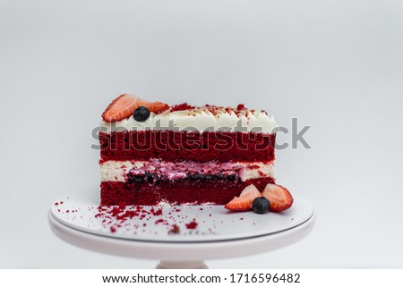Delicious homemade red velvet cake with fresh berries on white background