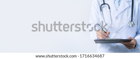 Doctor with stethoscope in white coat holding clipboard, writing medical record diagnosis, isolated on white background, close up, cropped view. Royalty-Free Stock Photo #1716634687