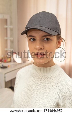Portrait of a young beautiful girl in a black cap, smiling.