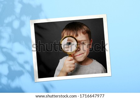 white photo card with a child on a Saffron blue colored wall with a shadow from a tree