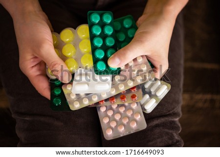 Many different medications, tablets in the hands of a woman. Concept of expensive medicine. The ability to select drugs from different pharmaceutical companies.