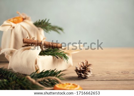 Zero waste christmas concept. Packed in natural fabric gifts and decorations from natural materials on gray table, copy space