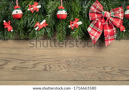 Christmas tree branches with red decorations on a wooden wall background. Template for greeting card or design. Horizontal banner with copy space