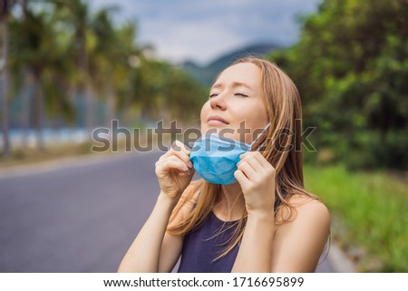 Quarantine is over concept. Woman taking off mask outdoor. We are safe. Coronavirus ended. We won. No more quarantine. Breathe deep. Take off the mask. Coronavirus is over Royalty-Free Stock Photo #1716695899