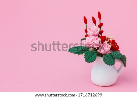 Artificial  unfading  roses  in a jug made of polymer clay as a symbol of eternal love. Valentine's  card concept.