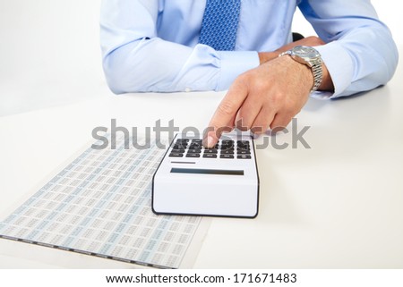 Mature businessman and calculator. Calculation at office