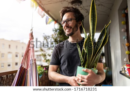 Young man taking care of his plants on a balcony
 Royalty-Free Stock Photo #1716718231