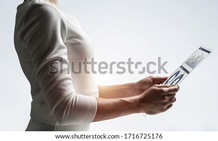 Woman hand touching virtual screen with pen. Online project management and financial diagrams visualization. Modern business innovation and intelligence technology. Data analysis futuristic concept