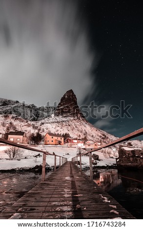 Night long exposure shot, photos in Reine, Small fishing village in Lofoten, Norway during winter with big mountains, peak clouds and amazing view from bridge
