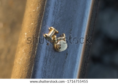 Handmade metal brass rivets located on the rail.