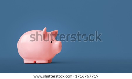 Piggy bank isolated on blue background Royalty-Free Stock Photo #1716767719
