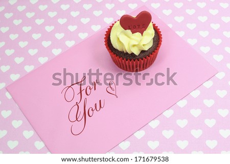 Red velvet cupcakes with vanilla frosting and cute red hearts with love messages for Valentines Day, Mothers Day, birthday Christmas or special romantic occasion.