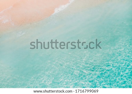 Tropical beach with a bird's eye view of the waves breaking on the tropical Golden sandy beach. Sea waves gently loop along the beautiful sandy beach.