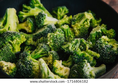 Frozen green cabbage, semi-finished product in a pan. Cooking broccoli cabbage.