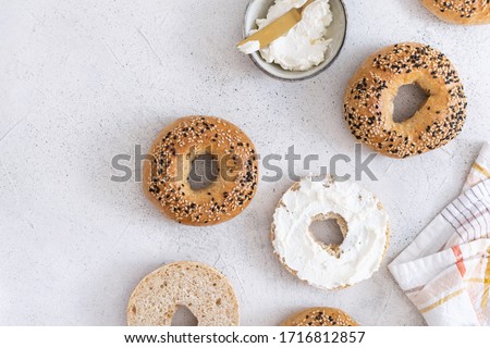 Fresh baked sourdough New York style bagels with philadelphia cheese on light table, top view Royalty-Free Stock Photo #1716812857