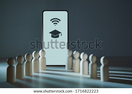 Online training or Online education. E-learning. Distance webinar. Wooden figures of students near screen of smartphone.