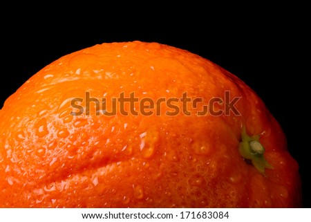 orange with water drops close-up isolated on black background. macro texture 