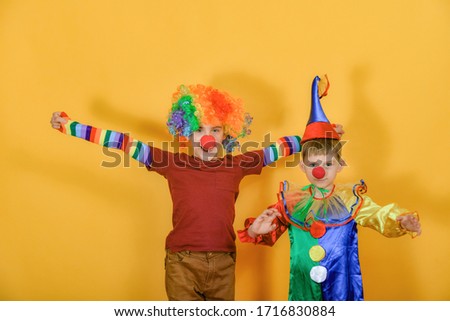 Two clowns hug and wave their arms around.