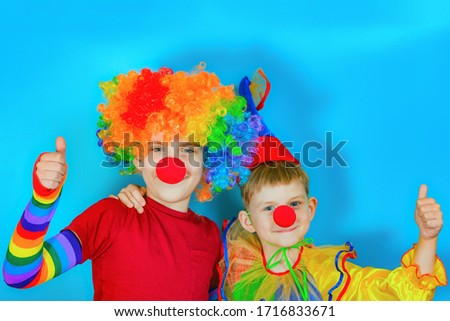 Two clowns cuddle and put their thumbs up.