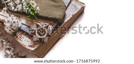 May 9, Victory Day holiday. Holiday card with order, St. George ribbon, flowers and military cap. May 9 background, copy space and translation with Victory Day.