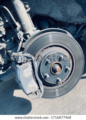 Brake disk and suspension parts. Replacing wheel on modern SUV car, Close-up blue toned photo