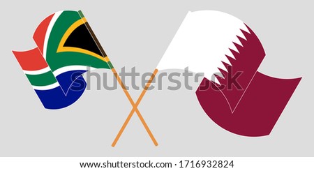 Crossed and waving flags of South Africa and Qatar
